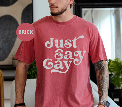 a man wearing a red shirt that says just say gay