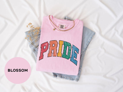 a pink shirt with the word pride printed on it