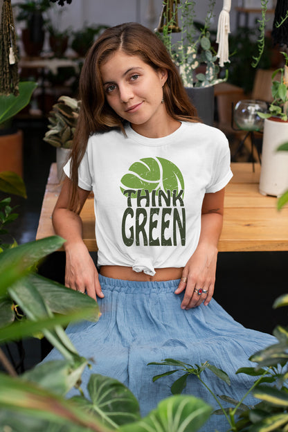 a woman sitting on a bench wearing a white shirt that says think green