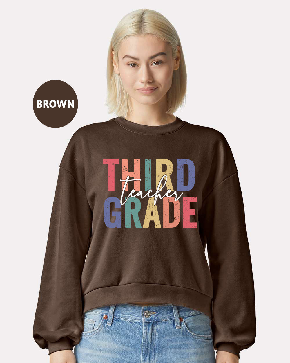 a woman wearing a brown sweatshirt that says third grade