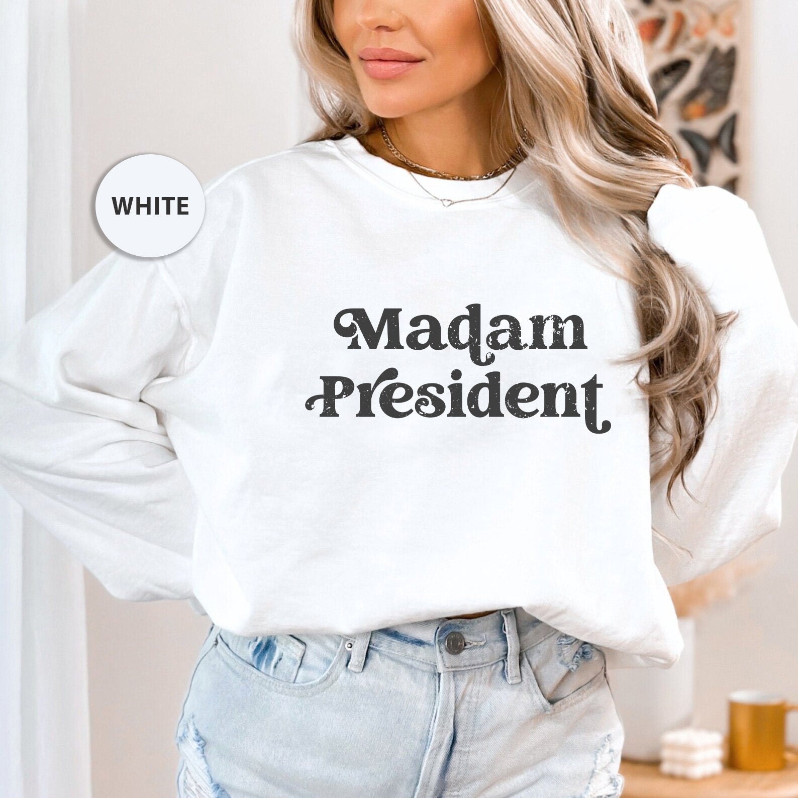 a woman wearing a white sweatshirt that says madam president