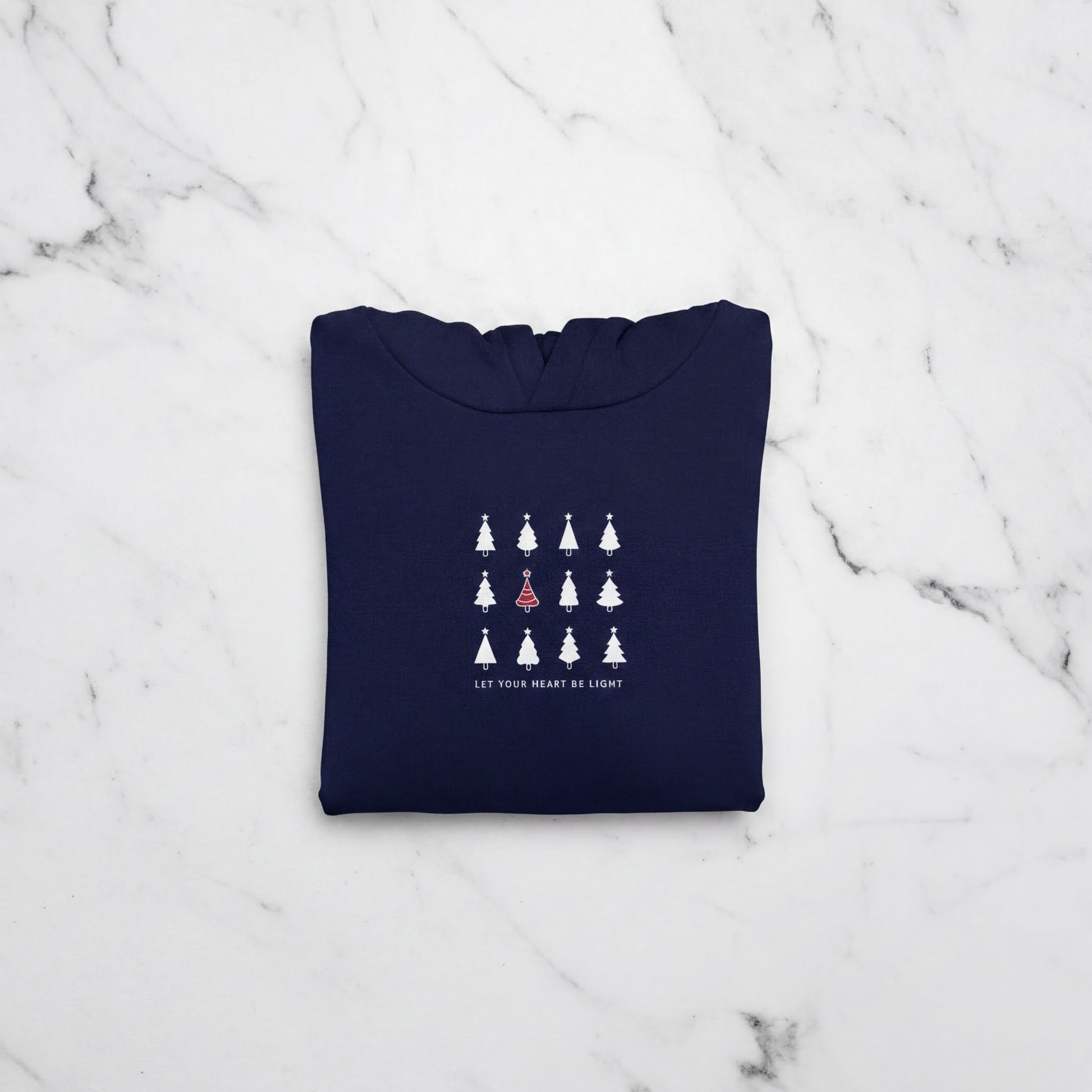 A navy blue hoodie with a white graphic design on the front, featuring a row of white Christmas trees with a single red tree in the center.