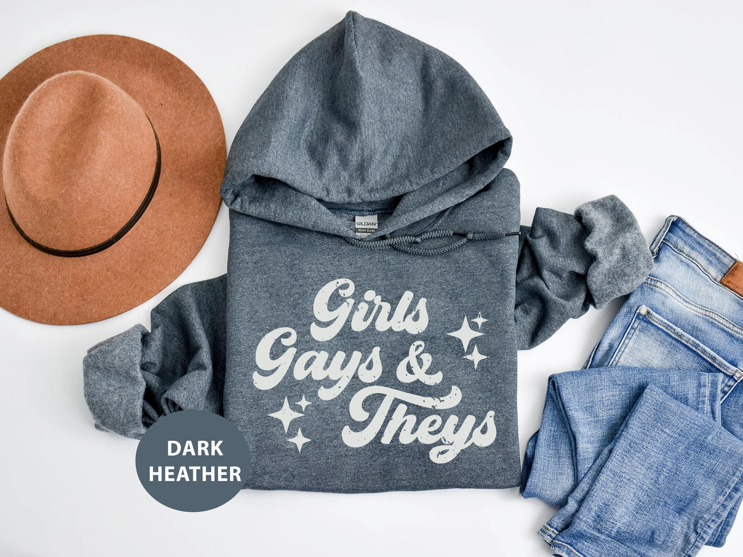 a hoodie, jeans and a hat on a white surface