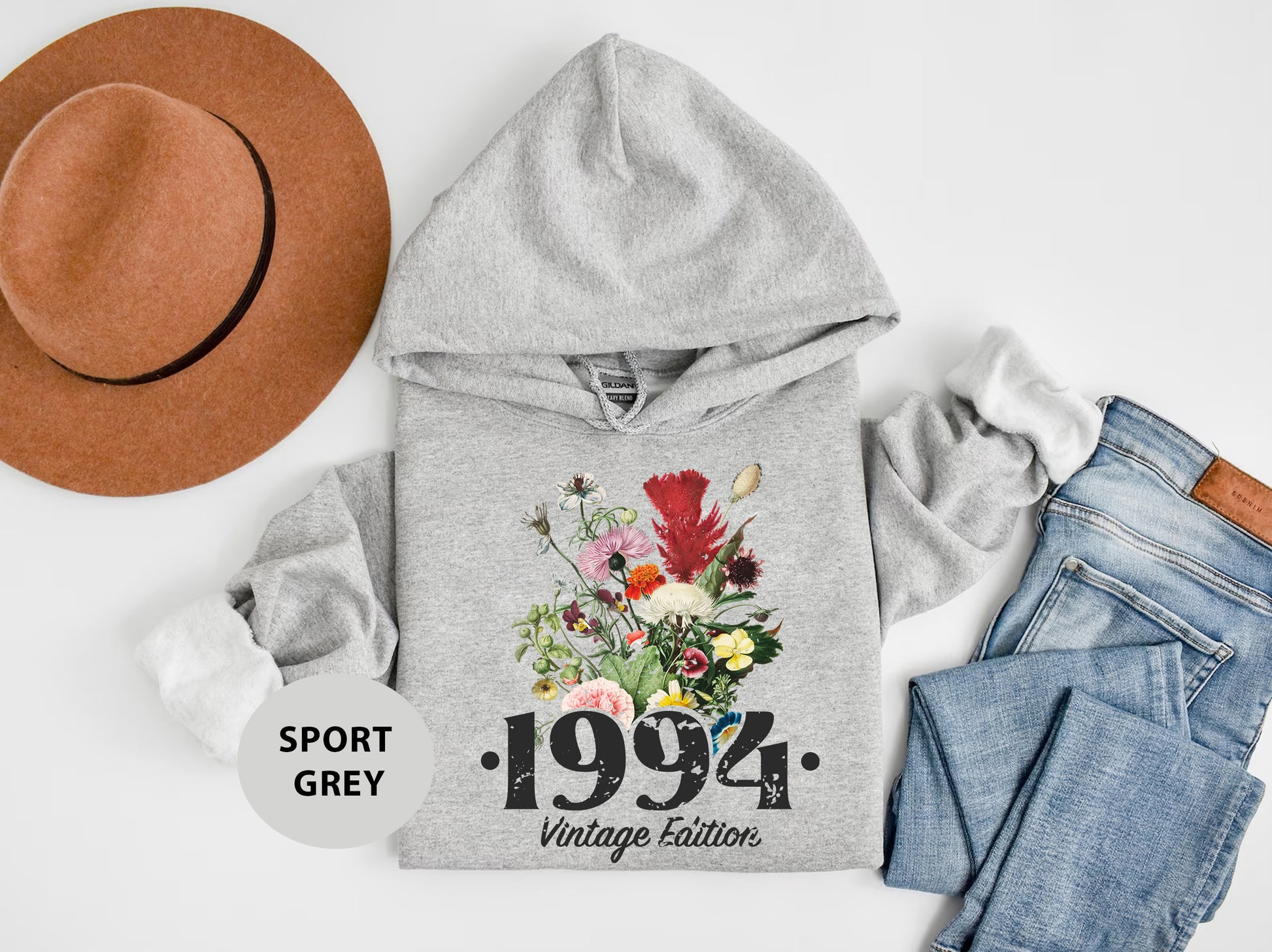 a gray hoodie with flowers and a hat on top of it