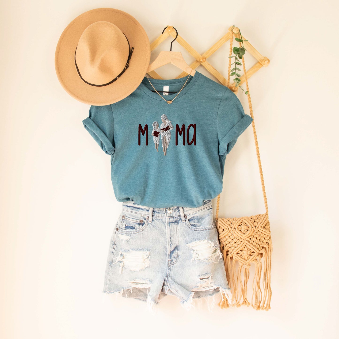 a t - shirt that says mom with a cowboy hat and a straw bag