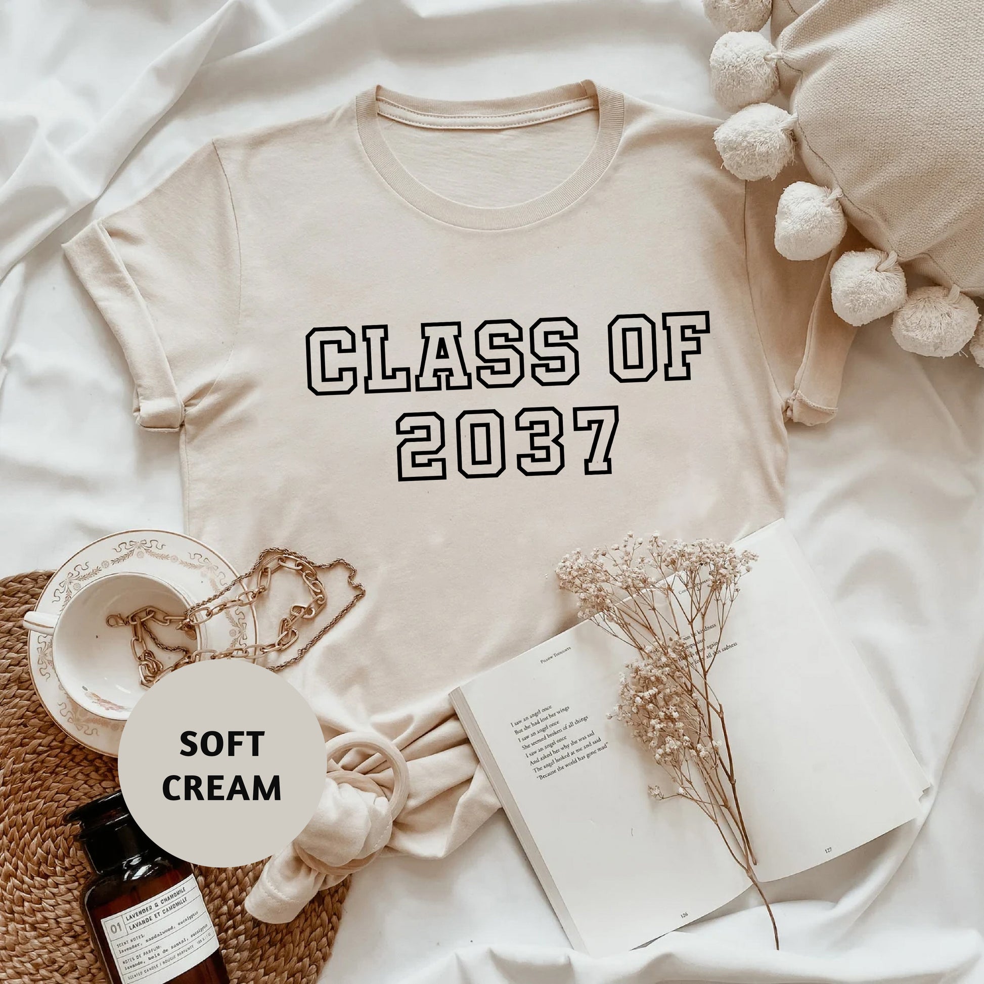 a t - shirt that says class of 2077 next to a bottle of cream