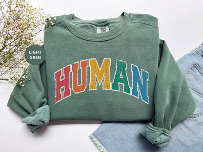 a green sweatshirt with the word human printed on it