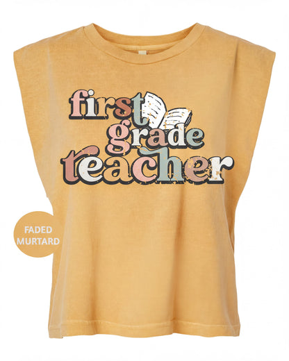 A yellow t-shirt with the text "first grade teacher" printed on it.
