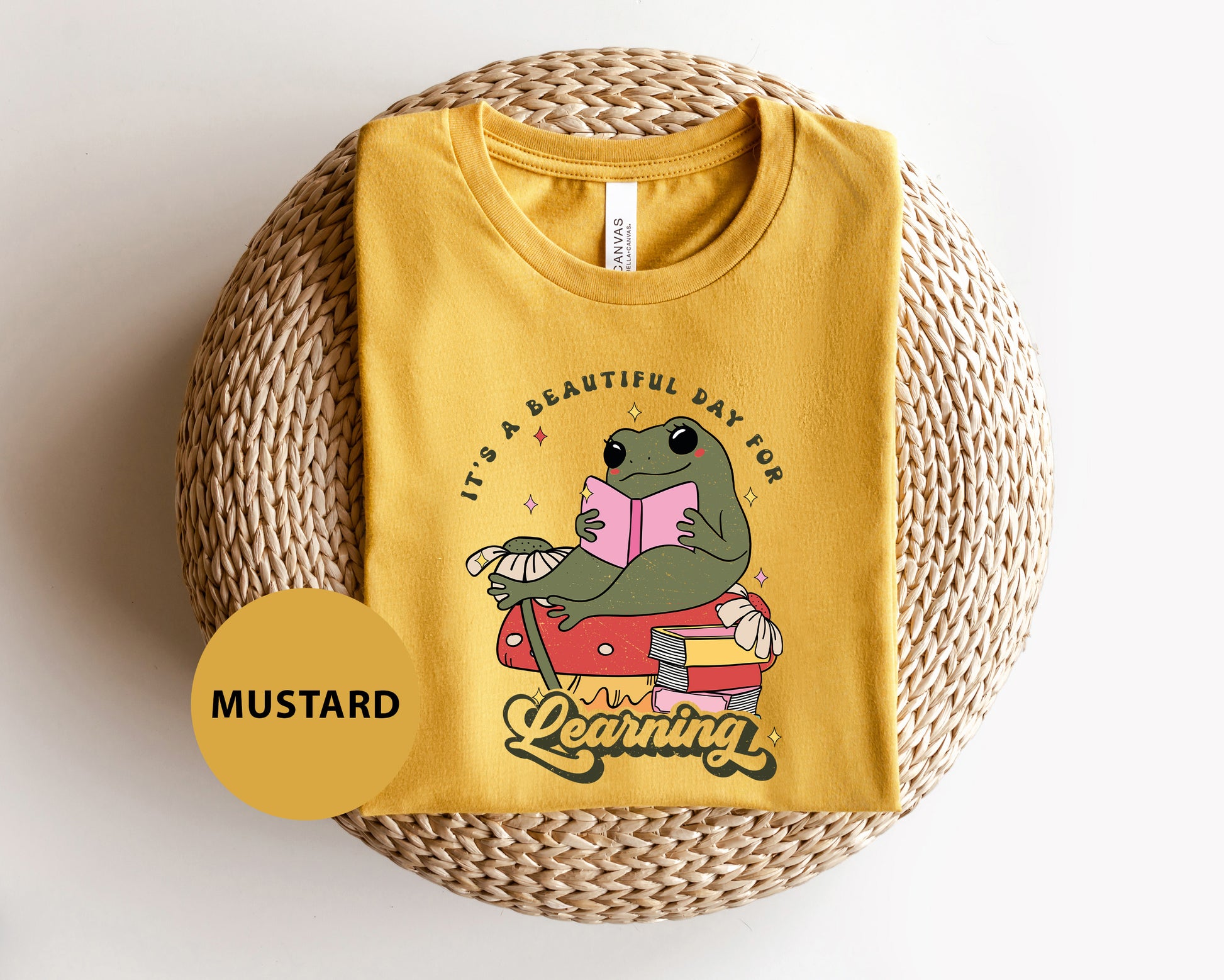 a yellow t - shirt with a dinosaur reading a book