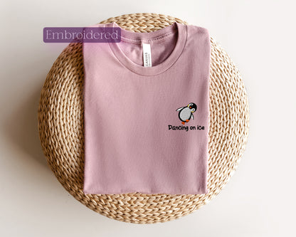 a pink t - shirt with a penguin embroidered on it