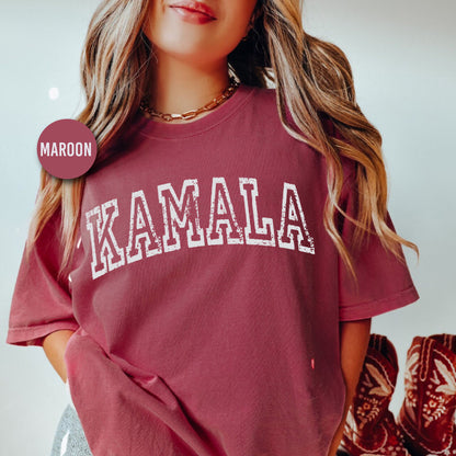 a woman wearing a maroon shirt with the word kaamala printed on it