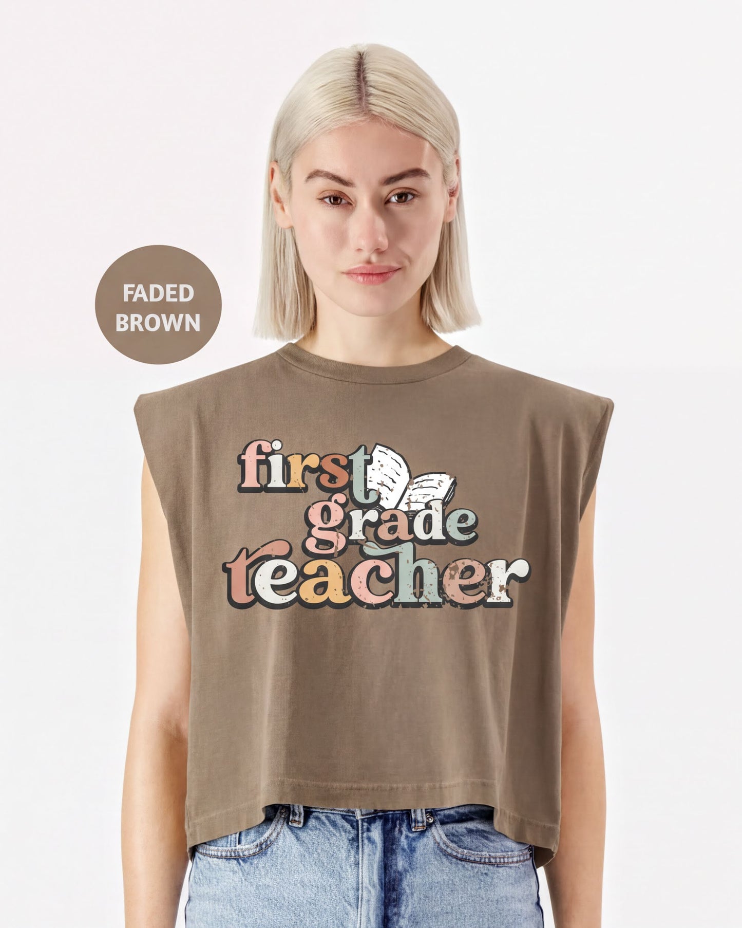 A woman wearing a brown t-shirt with the text "first grade teacher" printed on it.