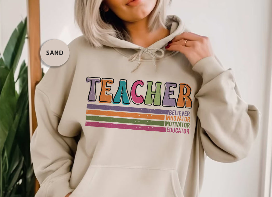 a woman wearing a sweatshirt with a teacher on it