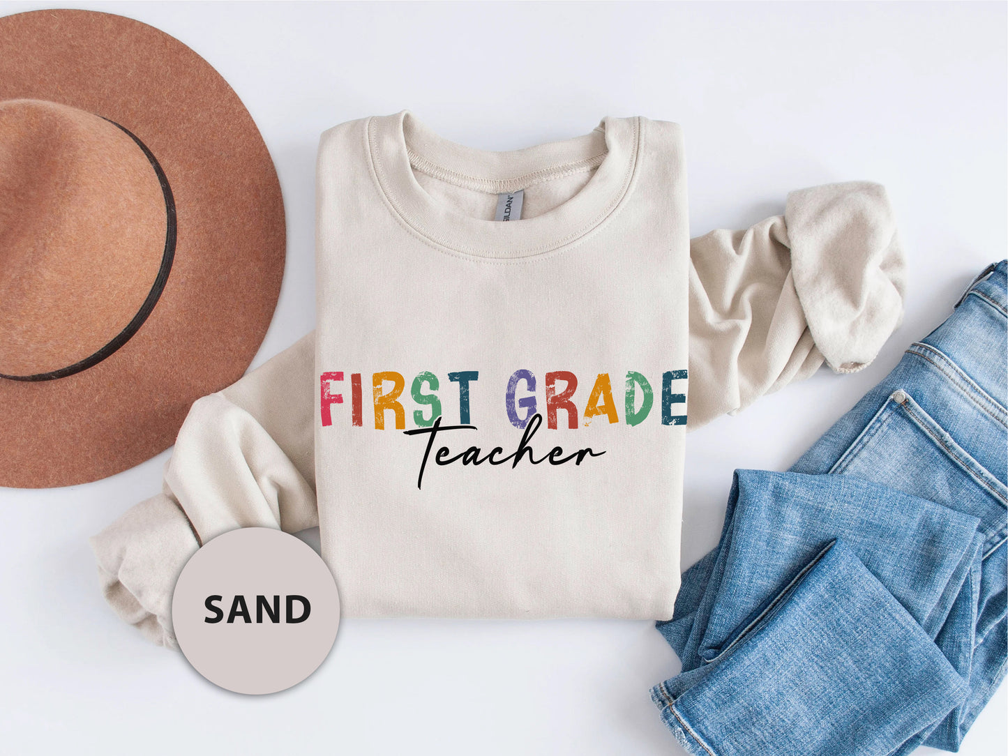 a shirt that says first grade teacher next to a hat and jeans