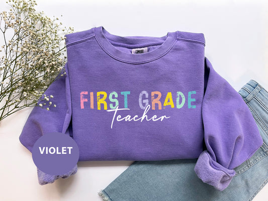 a purple shirt with the words first grade teacher on it