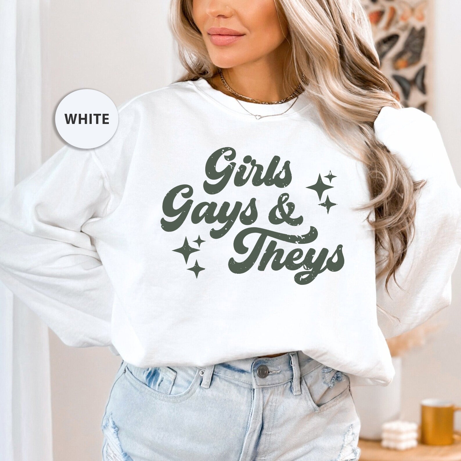 a woman wearing a white sweatshirt that says girls gays and they