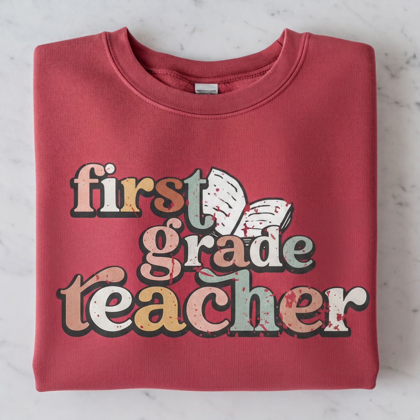 A red sweatshirt with the text "first grade teacher" printed on it.
