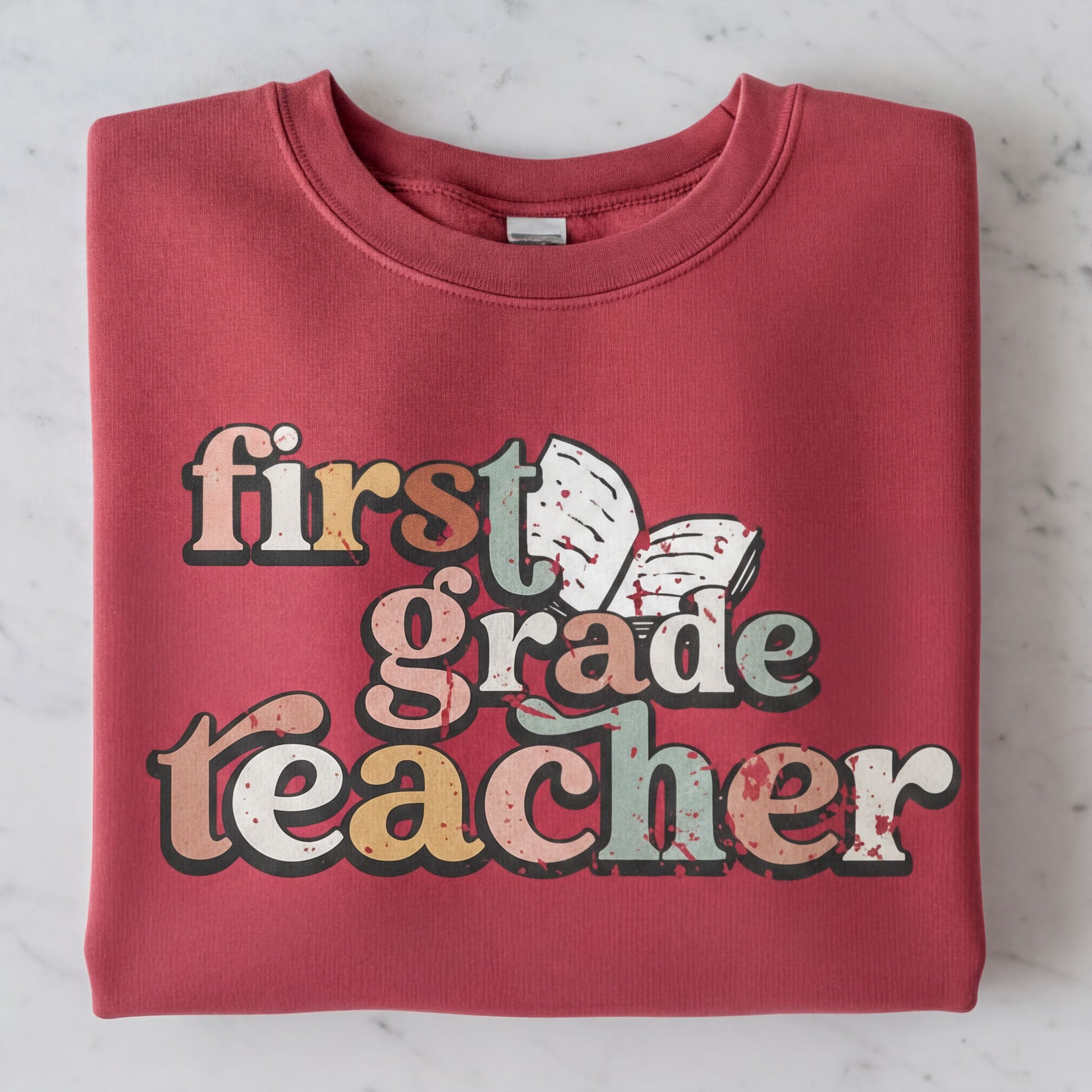 A red sweatshirt with the text "first grade teacher" printed on it.