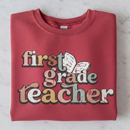 A red sweatshirt with the text "first grade teacher" printed on it.