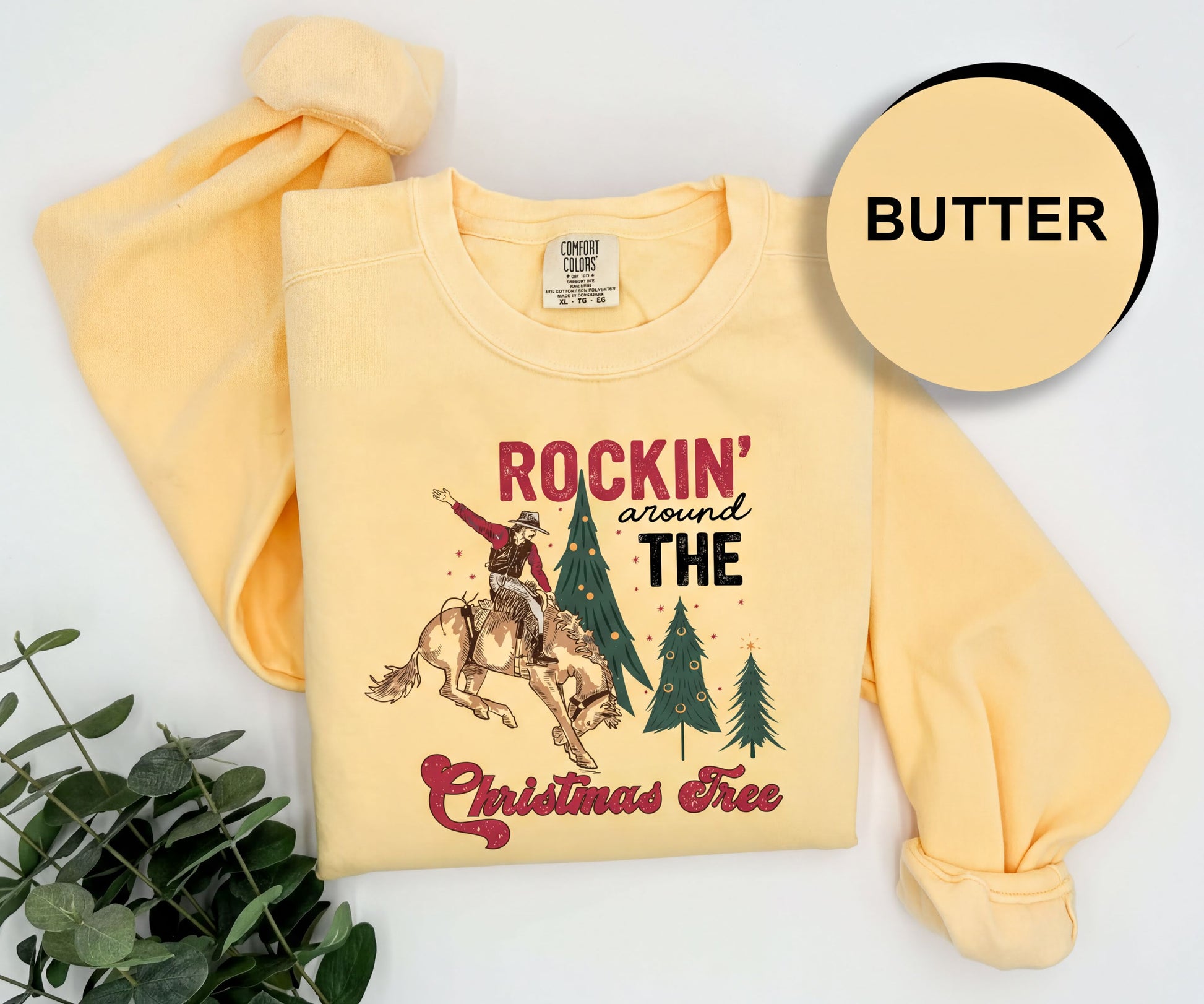 A yellow t-shirt with a graphic design and text, along with a plant and a circular logo with the word "BUTTER" on it.