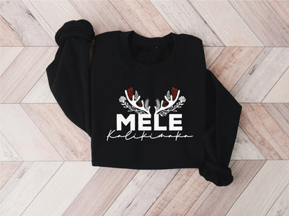 A black sweatshirt with a white graphic design and text printed on it, laid out on a wooden surface.