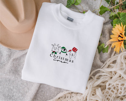 A white t-shirt with a Christmas-themed graphic design, including a reindeer, penguin, and snowman, along with the text "Christmas" printed on it.