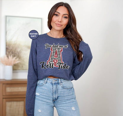 a woman wearing a blue sweatshirt with a red and white checkered letter on it