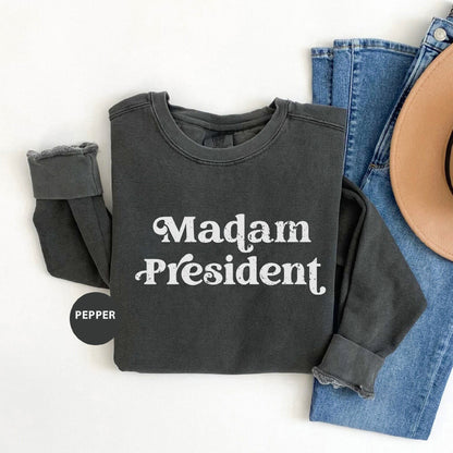 a shirt that says madam president next to a cowboy hat