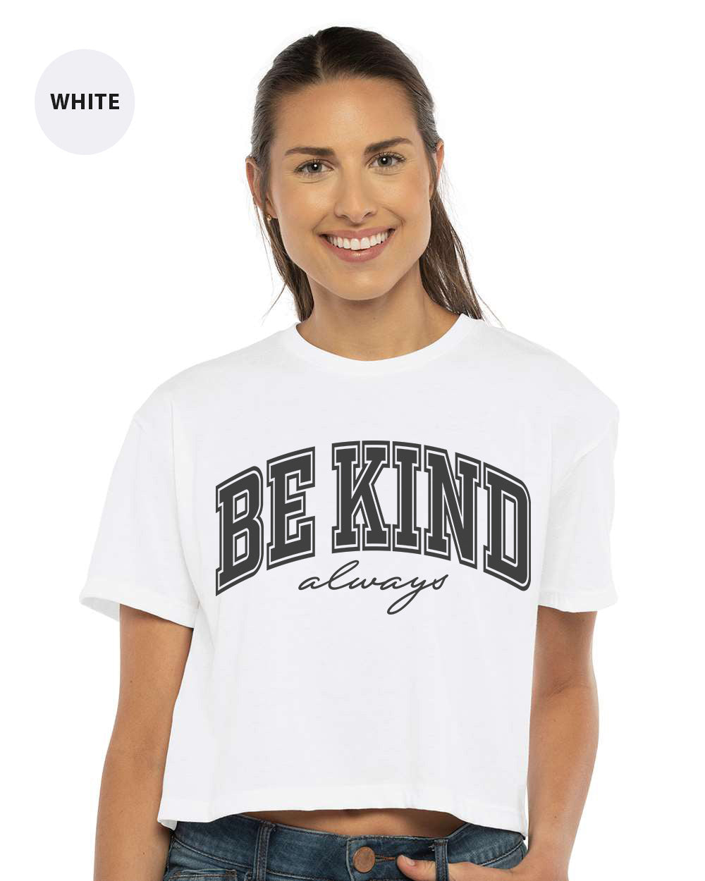 a woman wearing a white crop top with the words be kind on it