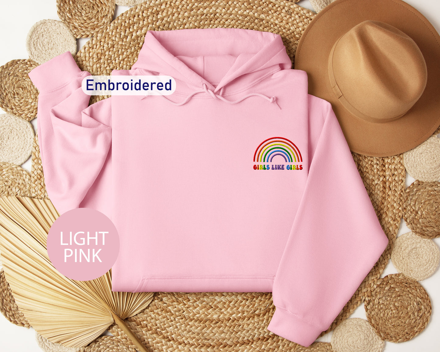 a pink hoodie with a rainbow embroidered on it