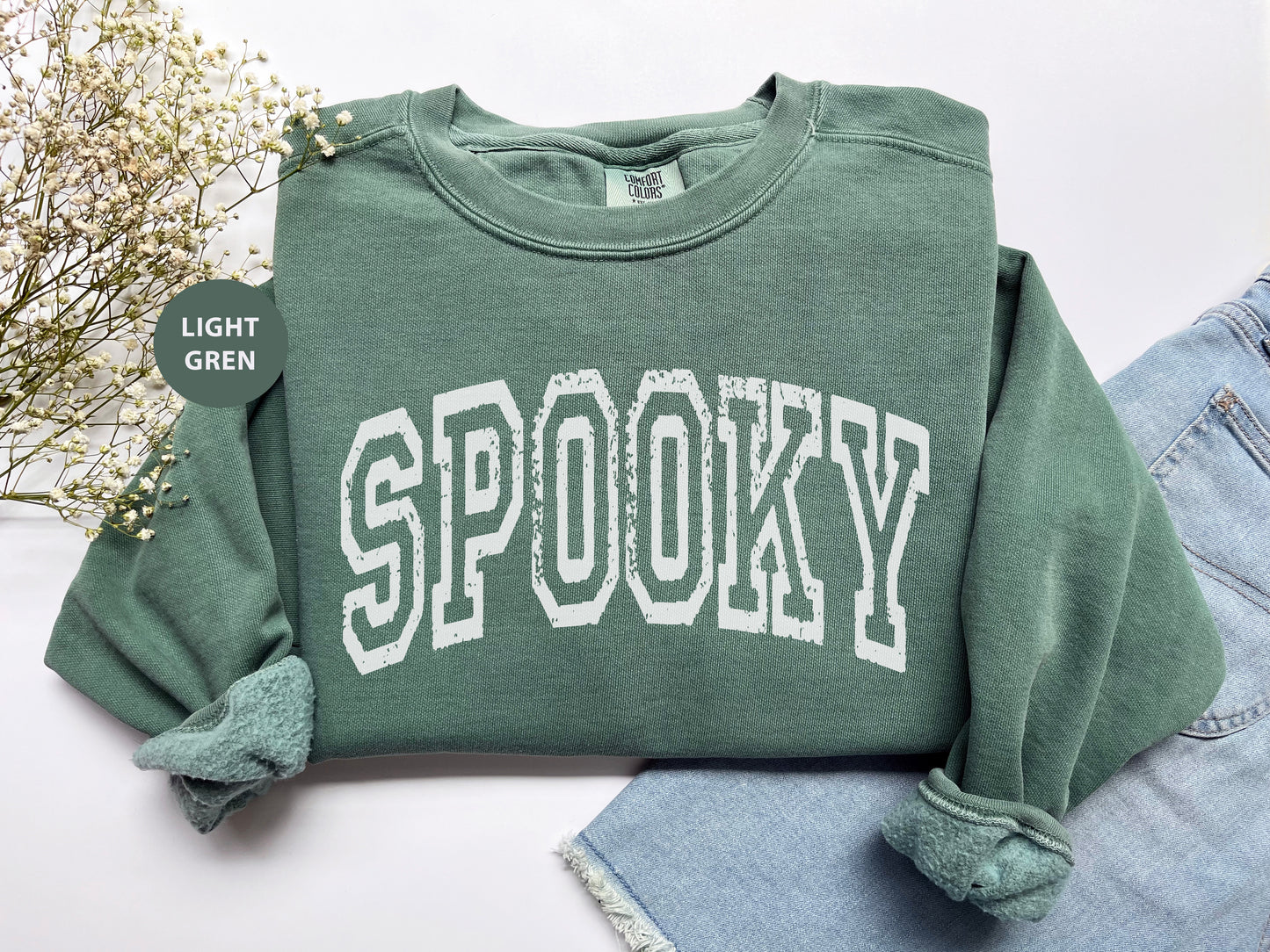 a green sweatshirt with the word spooky printed on it