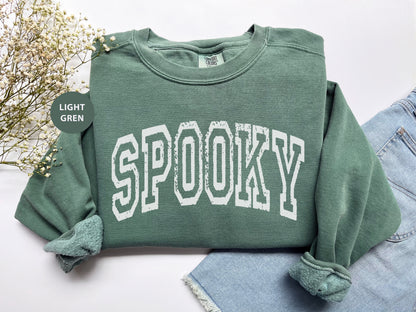 a green sweatshirt with the word spooky printed on it