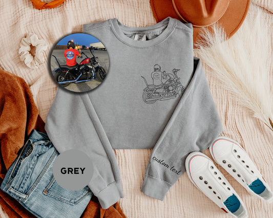 a grey shirt with a picture of a man on a motorcycle and a pair of