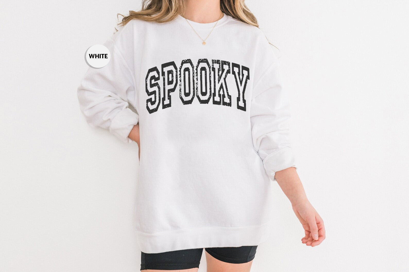 a woman wearing a white sweatshirt with the word spooky on it