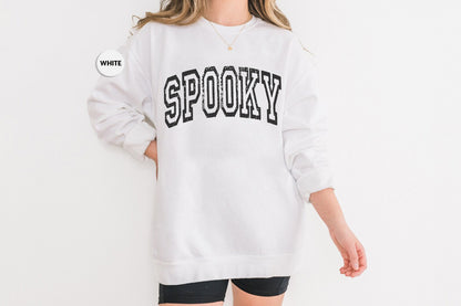 a woman wearing a white sweatshirt with the word spooky on it