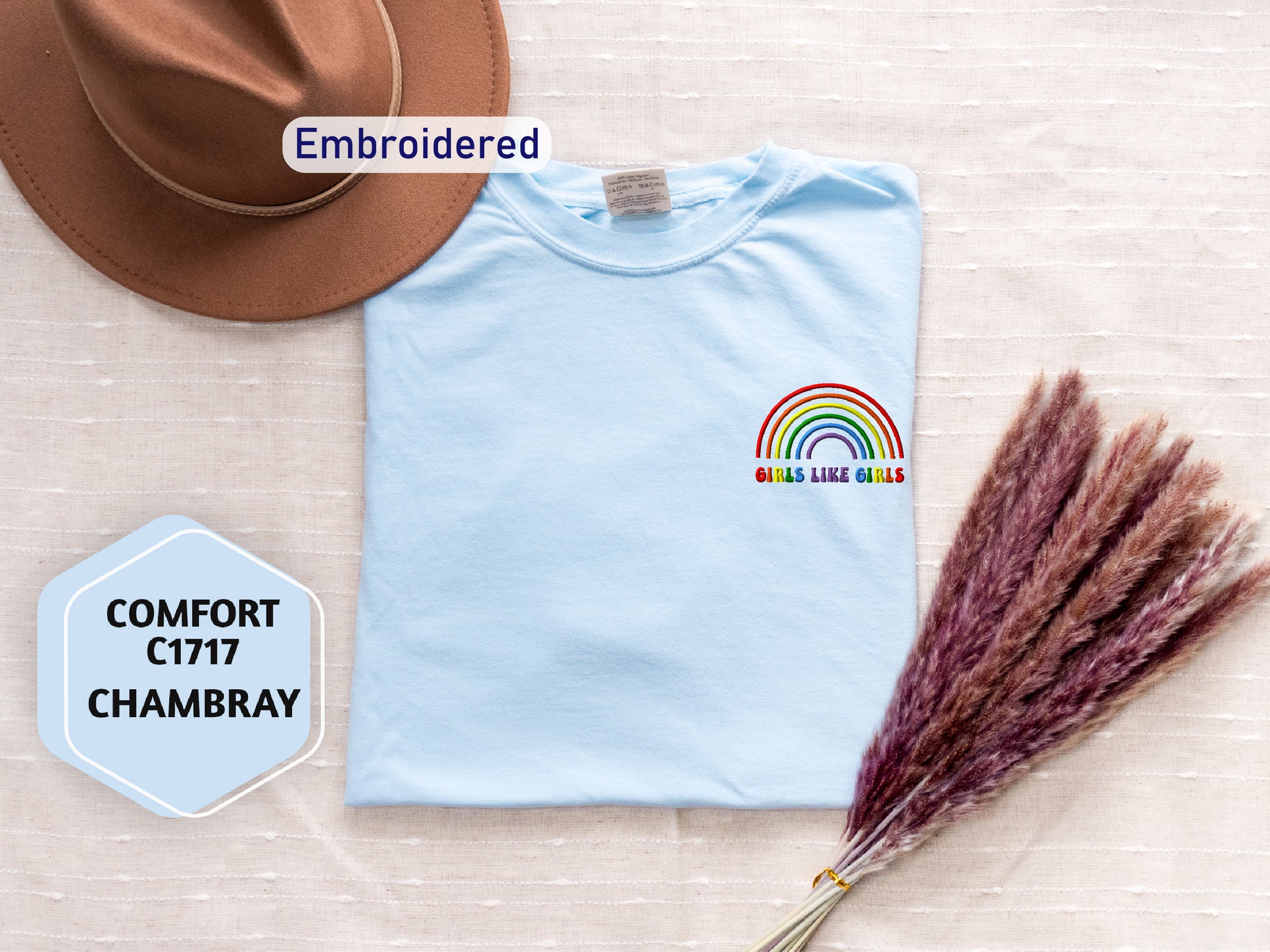 a t - shirt with a rainbow on it and a hat next to it