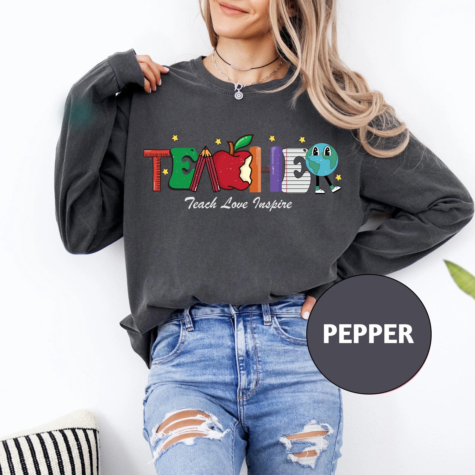 a woman wearing a sweatshirt with the words teach love inspire on it