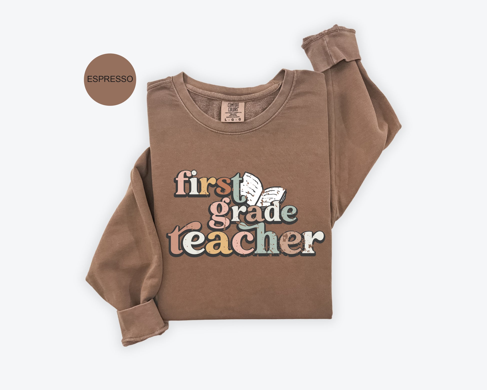 A brown sweatshirt with the text "first grade teacher" printed on it.