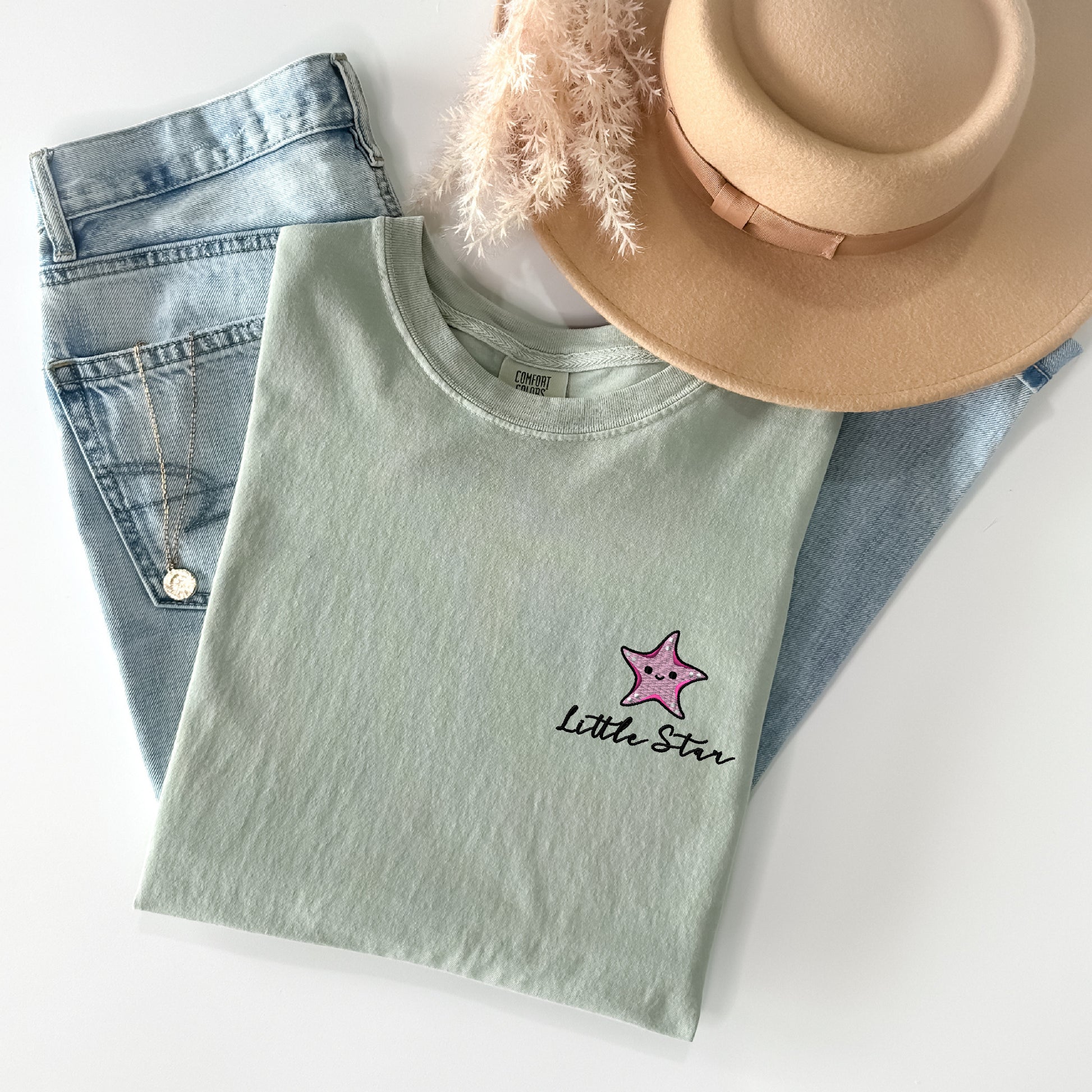 a hat, jeans, and a t - shirt on a white surface