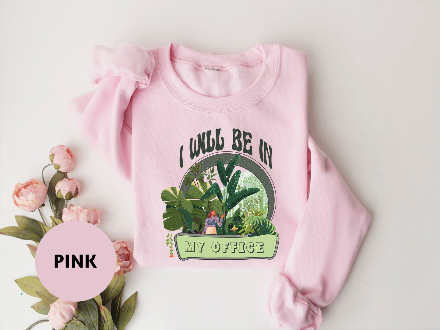 a pink sweatshirt with a picture of a girl in a jungle on it