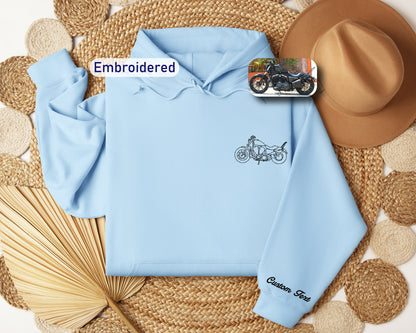 a blue hoodie with a motorcycle embroidered on it