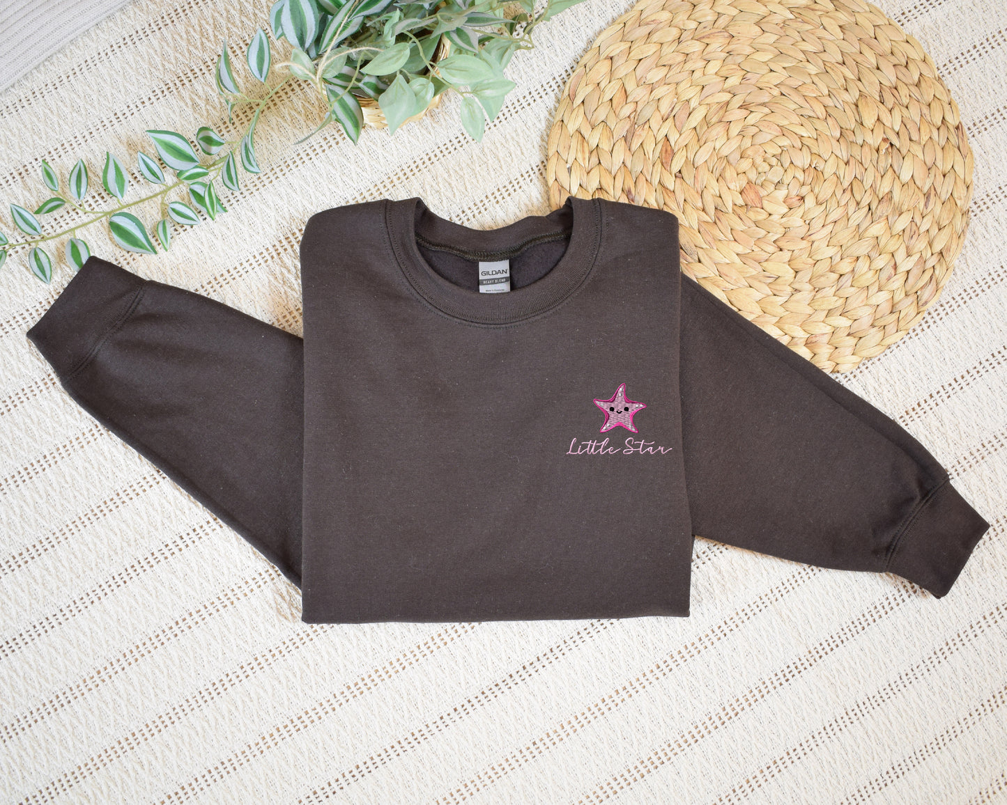 a brown shirt with a pink star on it