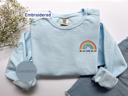 a blue shirt with a rainbow embroidered on it