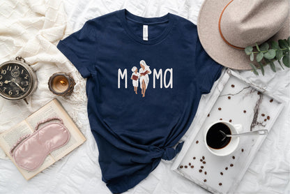 a t - shirt that says mom on it next to a cup of coffee