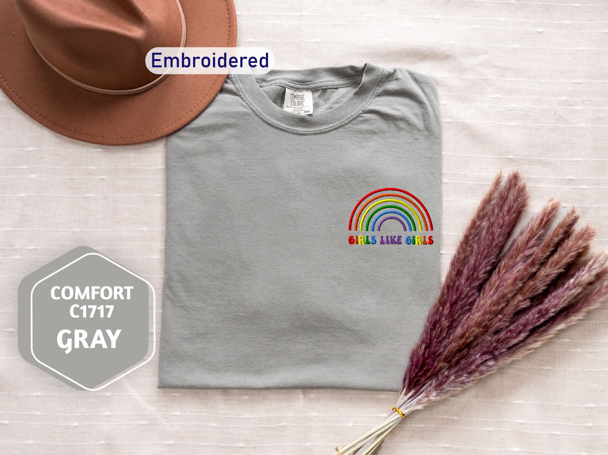 a t - shirt with a rainbow on it and a hat next to it