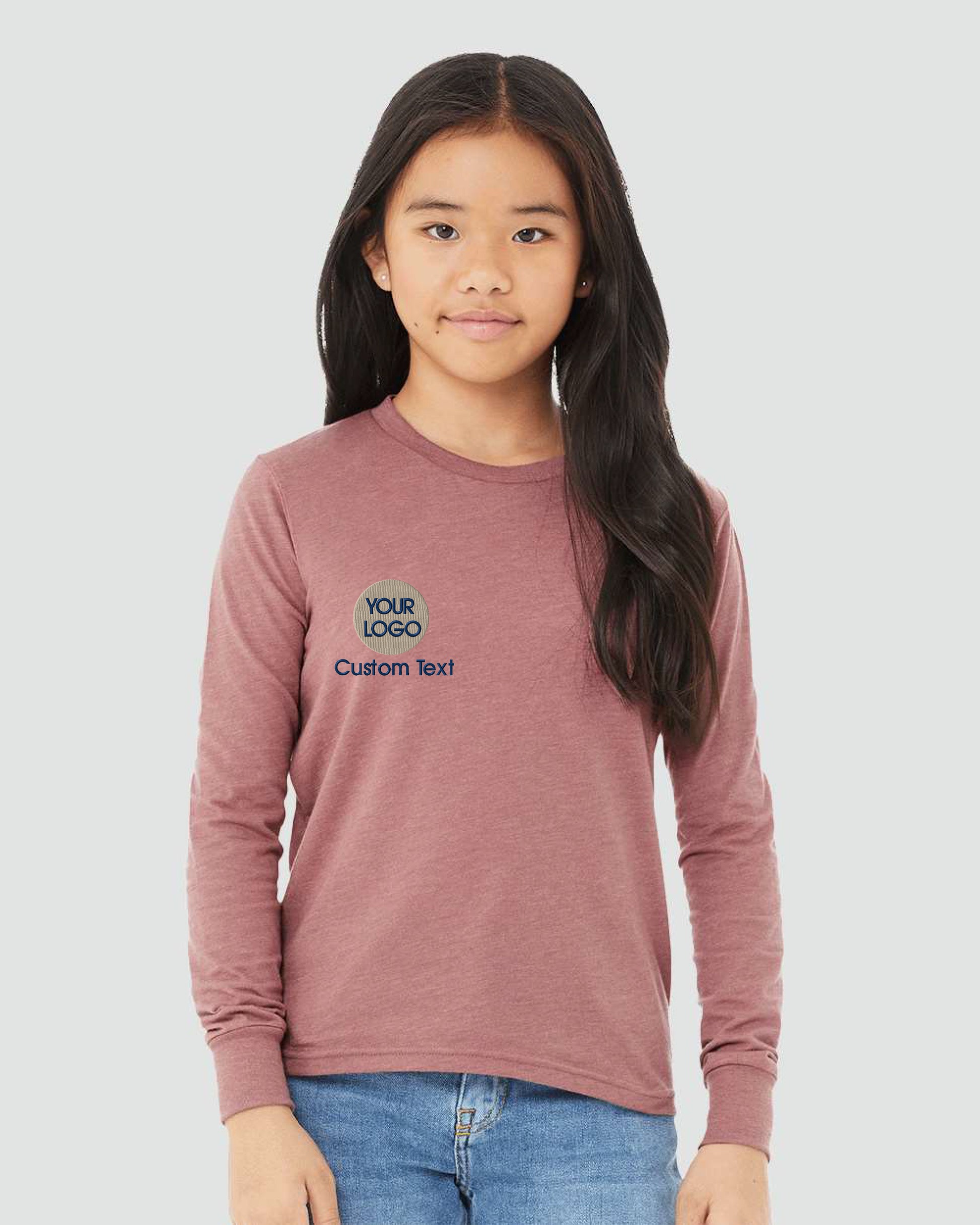 a young girl wearing a pink long sleeve shirt