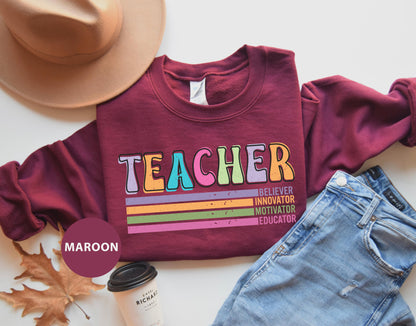 a t - shirt that says teacher next to a pair of jeans and a hat