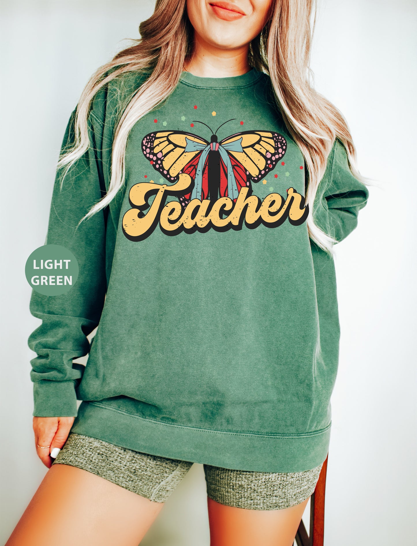 a woman wearing a green sweatshirt with a butterfly on it