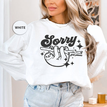 a woman wearing a white sweatshirt that says sorry