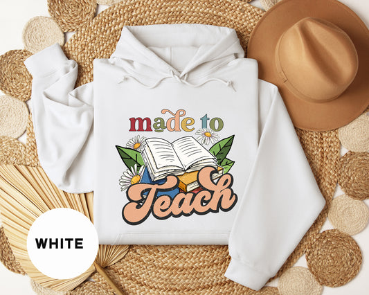 a white hoodie with the words made to teach on it